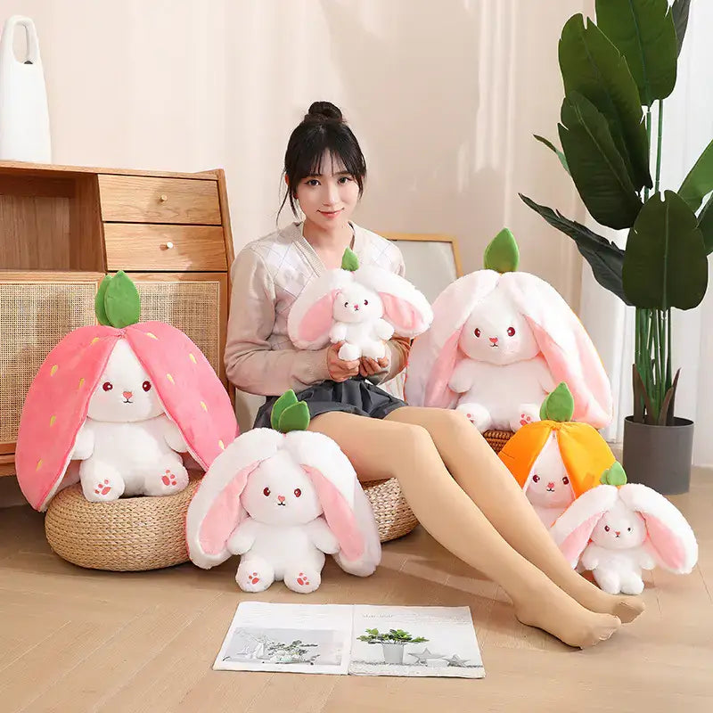 A collection of cute strawberry radish bunny plush toys with a young woman sitting among them, perfect for Easter décor.